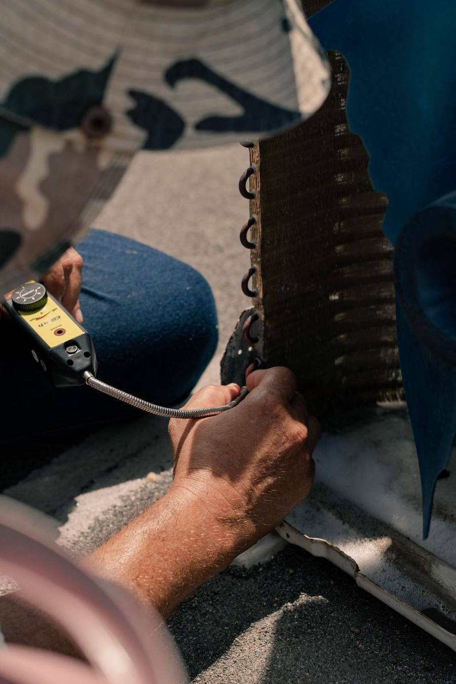Technician checking an air-conditioner condenser for a leak